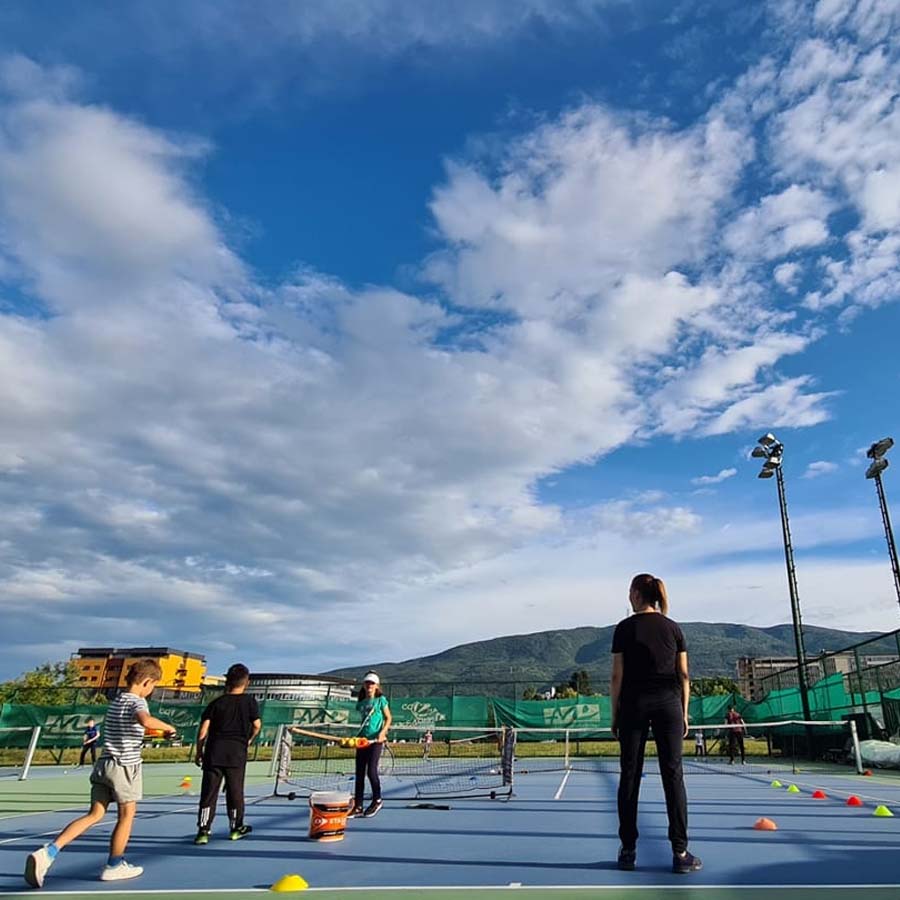 Учење правилен тениски сервис на терен.